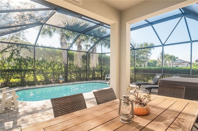 view of pool featuring a lanai, a patio area, and a hot tub