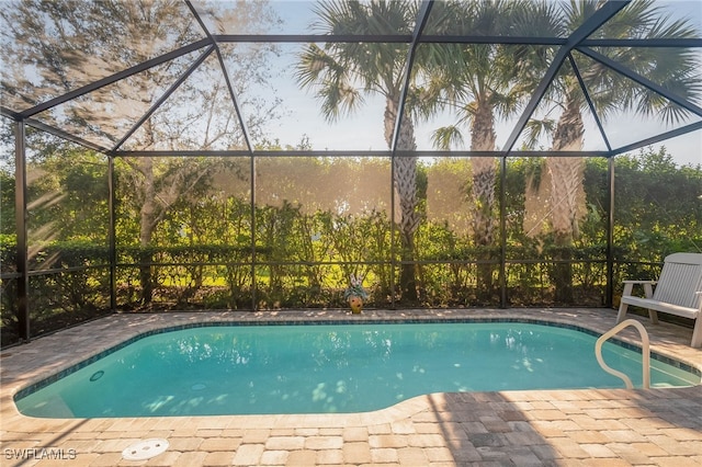 view of swimming pool featuring a patio area and a lanai