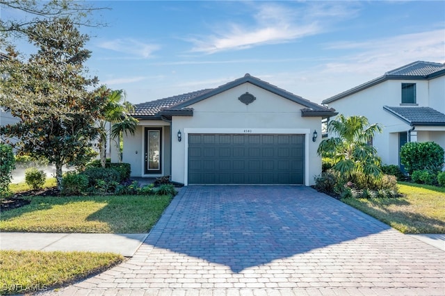 ranch-style house with a garage and a front lawn