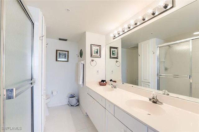 bathroom featuring tile patterned floors, vanity, a shower with shower door, and toilet