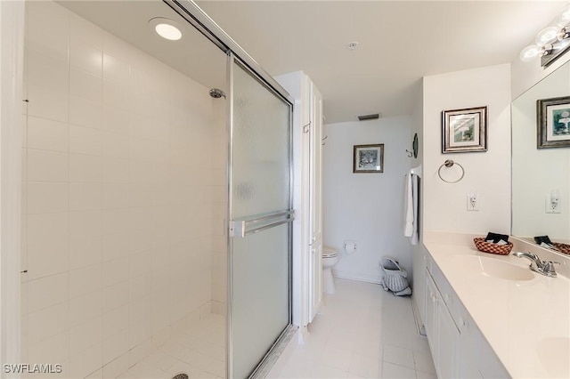 bathroom featuring tile patterned flooring, vanity, toilet, and a shower with shower door