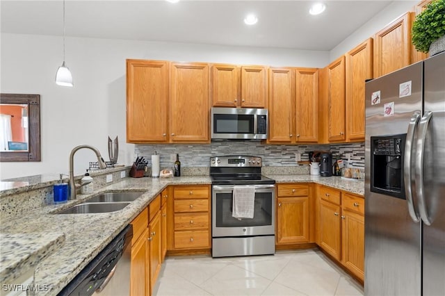 kitchen with sink, decorative backsplash, appliances with stainless steel finishes, decorative light fixtures, and light stone counters