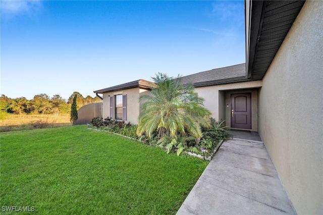 view of exterior entry with a lawn