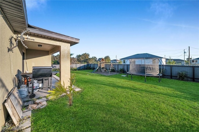 view of yard with a playground and a trampoline