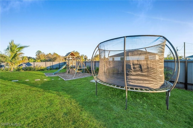 view of yard with a playground and a trampoline