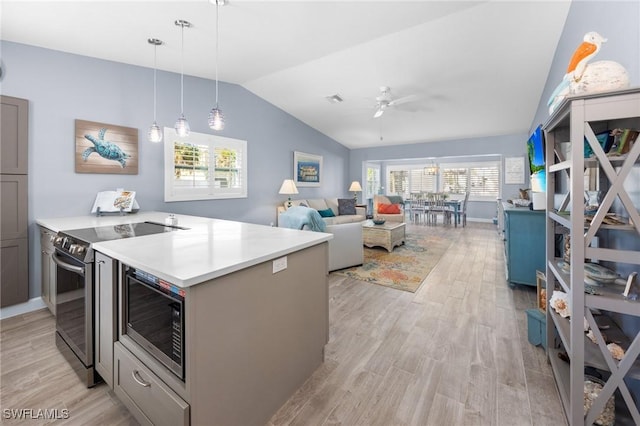 kitchen with appliances with stainless steel finishes, vaulted ceiling, ceiling fan, light hardwood / wood-style flooring, and hanging light fixtures