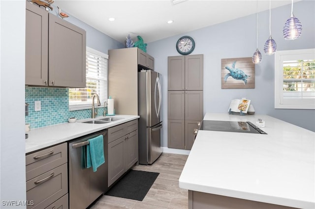 kitchen with appliances with stainless steel finishes, a wealth of natural light, pendant lighting, and sink