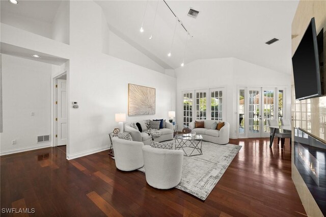 living room featuring french doors, high vaulted ceiling, and dark wood-type flooring