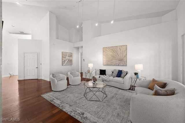 living room featuring high vaulted ceiling and dark hardwood / wood-style floors