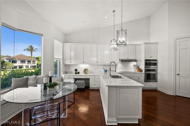 kitchen with sink, hanging light fixtures, white cabinets, dark hardwood / wood-style flooring, and stainless steel double oven