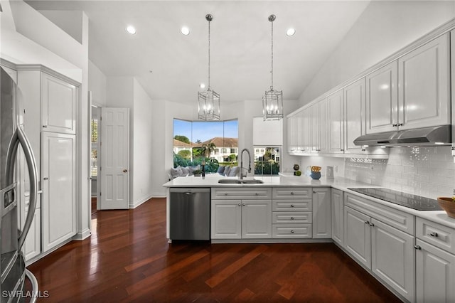 kitchen with sink, hanging light fixtures, kitchen peninsula, stainless steel appliances, and dark wood-type flooring