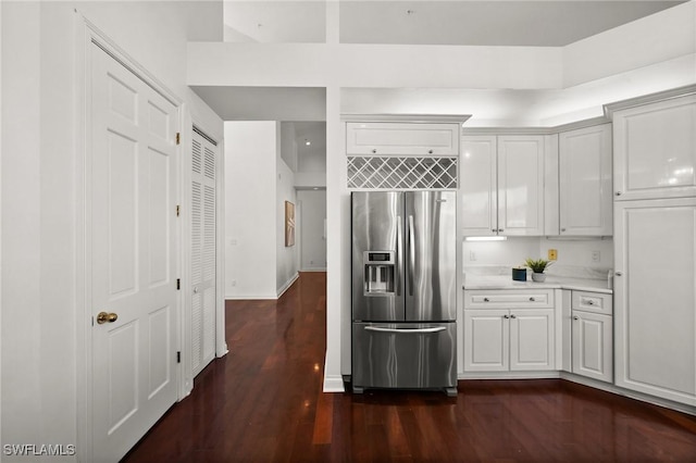 kitchen featuring stainless steel fridge, dark hardwood / wood-style flooring, and white cabinets