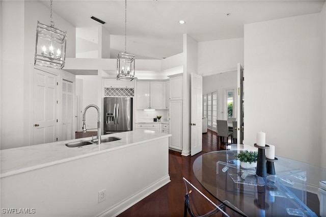 kitchen featuring decorative light fixtures, white cabinetry, sink, and stainless steel fridge with ice dispenser