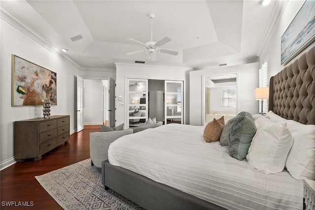 bedroom featuring a raised ceiling, crown molding, dark hardwood / wood-style floors, and ceiling fan