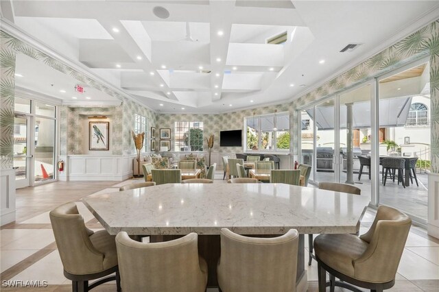 kitchen featuring ornamental molding, light stone countertops, a kitchen breakfast bar, and a spacious island