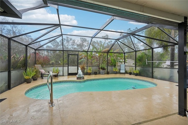 view of pool featuring glass enclosure and a patio