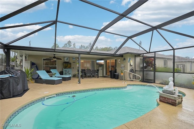 view of swimming pool featuring glass enclosure, pool water feature, ceiling fan, area for grilling, and a patio