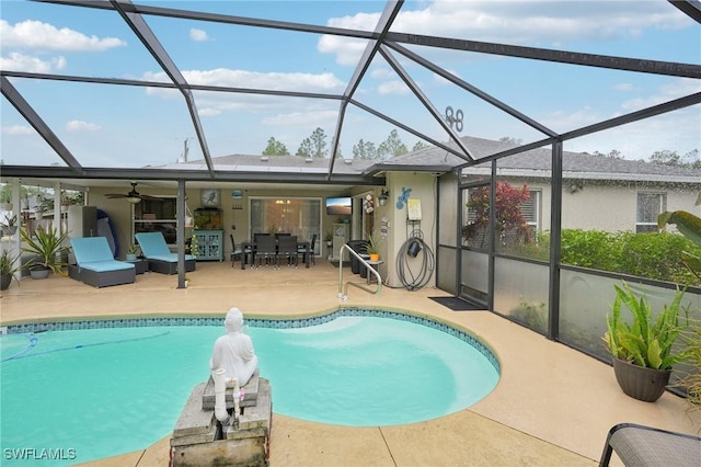 view of pool with a patio, glass enclosure, and ceiling fan