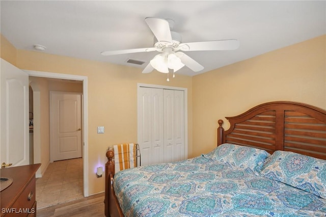 bedroom with light wood-type flooring, a closet, and ceiling fan