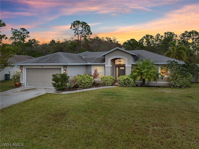 ranch-style house featuring a lawn and a garage