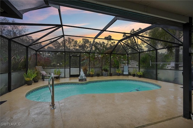 pool at dusk featuring glass enclosure and a patio area