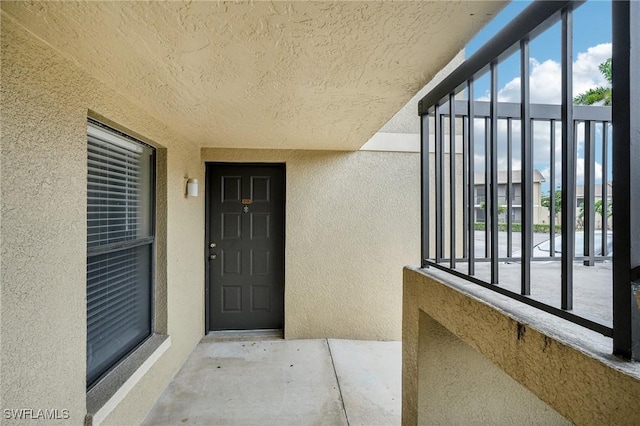 view of exterior entry with a balcony