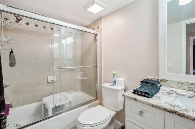 full bathroom with vanity, toilet, and bath / shower combo with glass door