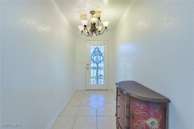 entryway featuring a notable chandelier and light tile patterned flooring