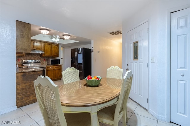 tiled dining space with ceiling fan