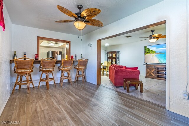 interior space with ceiling fan, hardwood / wood-style floors, and indoor bar