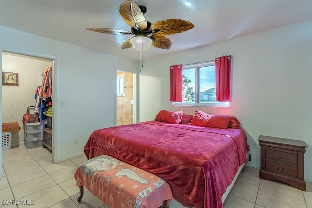 bedroom featuring light tile patterned floors, a walk in closet, ensuite bathroom, and ceiling fan