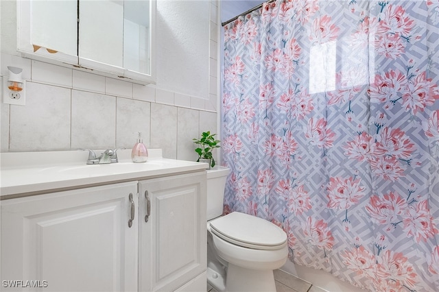 bathroom featuring backsplash, tile patterned floors, vanity, tile walls, and toilet