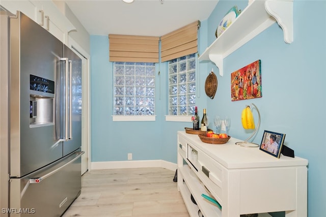 kitchen with white cabinetry, light wood-type flooring, and high quality fridge