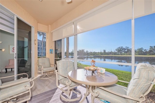 sunroom / solarium featuring a water view