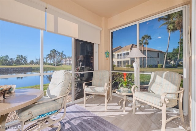 sunroom featuring a water view