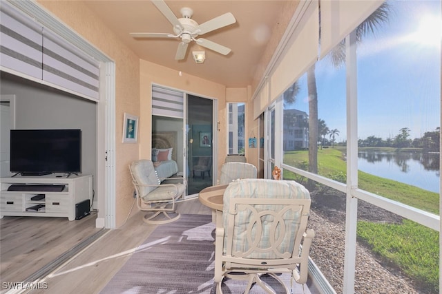 sunroom featuring a water view, a wealth of natural light, and ceiling fan