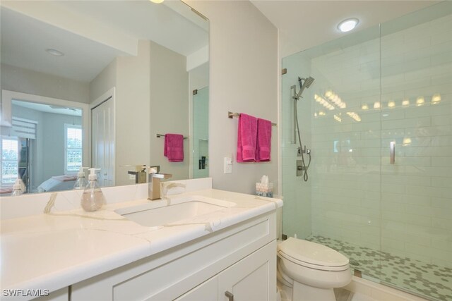 bathroom featuring vanity, toilet, and a shower with door