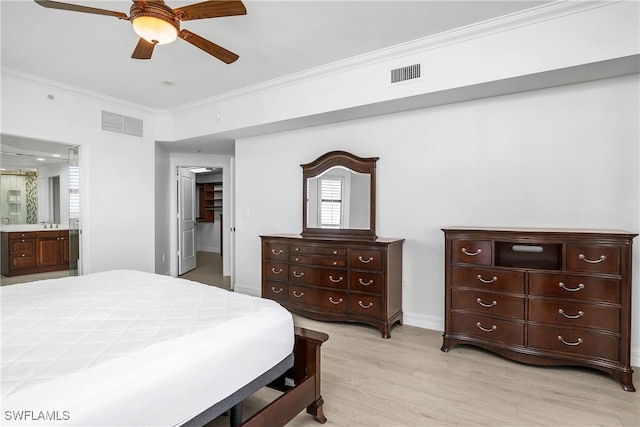 bedroom with connected bathroom, light hardwood / wood-style floors, ceiling fan, and ornamental molding