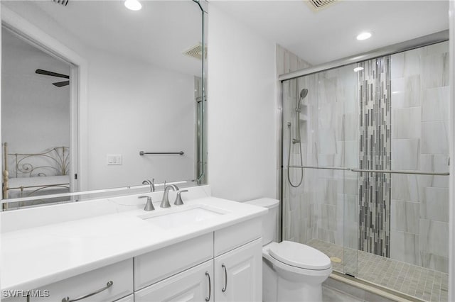 bathroom with vanity, a shower with shower door, and toilet