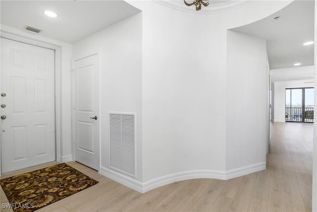 entrance foyer with light hardwood / wood-style floors and a chandelier