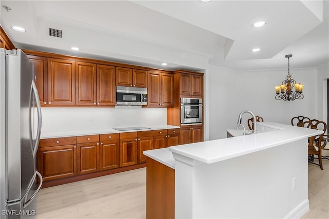 kitchen with stainless steel appliances, crown molding, pendant lighting, a notable chandelier, and light hardwood / wood-style floors