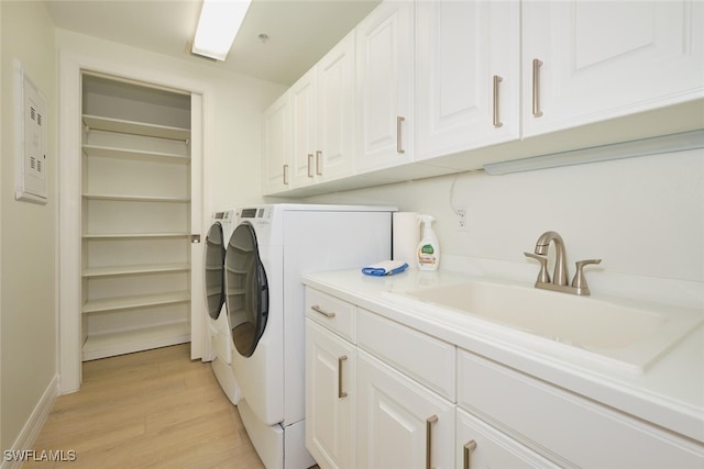 14300 Riva Del Lago Dr Unit 805, Fort Myers, FL 33907 - clothes washing area featuring washing machine and dryer, light wood-type flooring, cabinet space, a sink, and baseboards