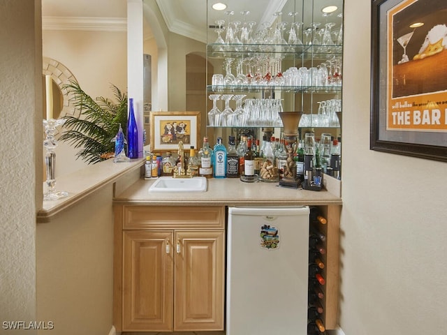 bar featuring white dishwasher, refrigerator, indoor bar, a sink, and crown molding