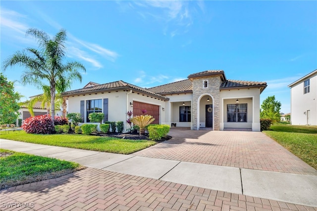 mediterranean / spanish house featuring a garage and a front lawn