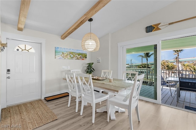 dining room with wood-type flooring and vaulted ceiling with beams