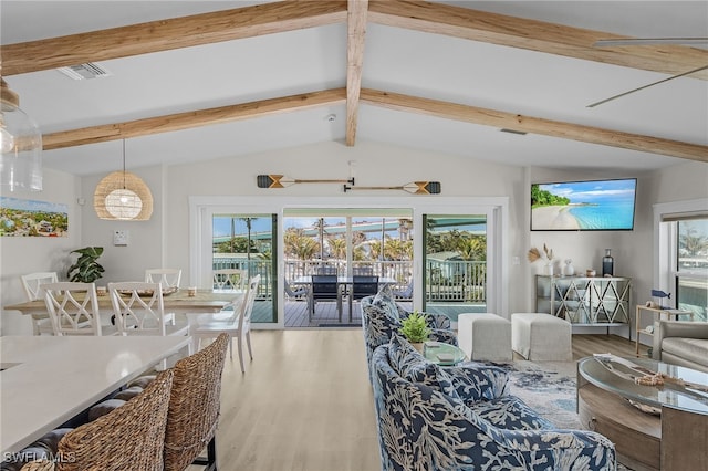 living room with vaulted ceiling with beams, plenty of natural light, and hardwood / wood-style floors