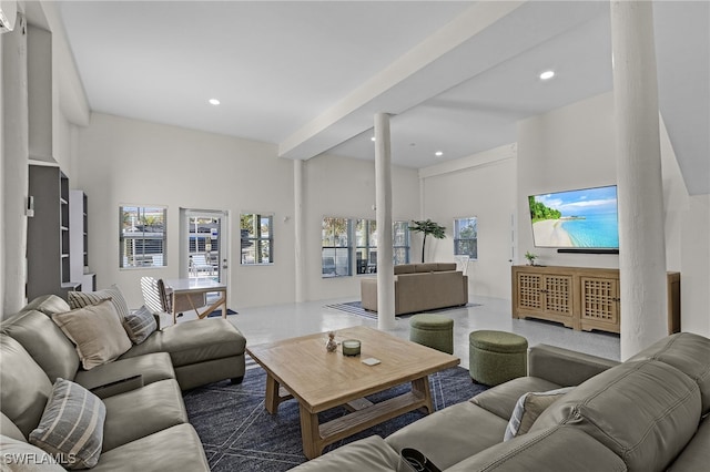 living room with beamed ceiling and a high ceiling