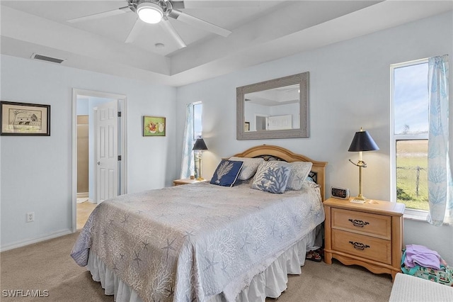 bedroom featuring ceiling fan, ensuite bathroom, and light carpet