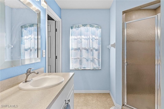 bathroom featuring tile patterned flooring, vanity, and walk in shower