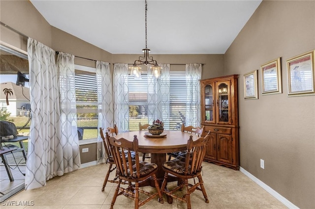 dining area with lofted ceiling, a notable chandelier, and light tile patterned flooring